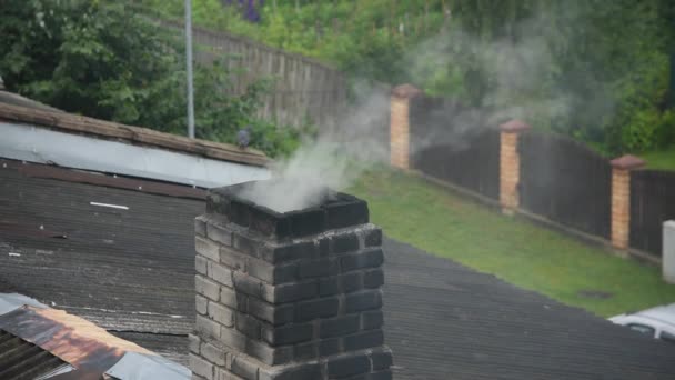 Fumo branco a sair da chaminé de tijolo queimado preto. Vento forte soprando fumaça branca da chaminé de tijolo no telhado — Vídeo de Stock