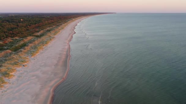 Drone aéreo disparado voando em direção ao mar ao longo da praia ao pôr do sol — Vídeo de Stock