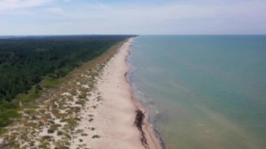 Letonya Baltık Denizi sahil kıyısı boyunca uçan hava manzarası. Sahildeki insanlar