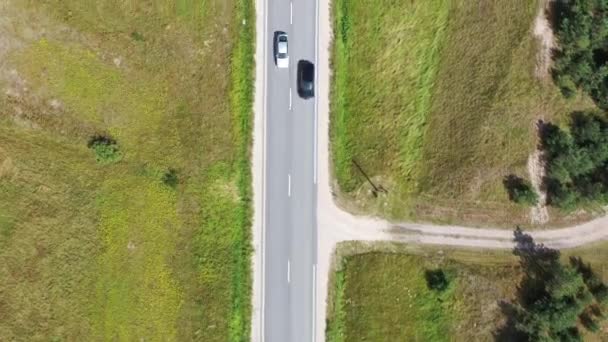 Vista aerea dall'alto verso il basso volando lungo la strada asfaltata con auto di guida — Video Stock