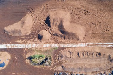 Havadan aşağıya turba toplama alanı ve turba yığınları görünüyor. Peat çıkarımı