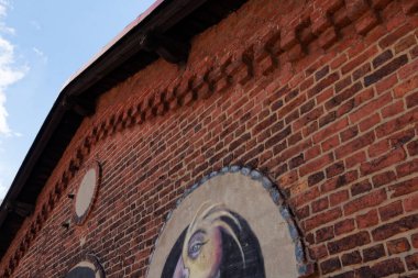 Çatının altında küçük bir duvar resmi olan tarihi binanın duvarları..