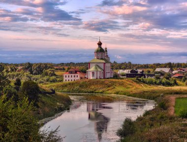 Yazın manzarası Vladimir yoğunluğu Rus ortodoks kiliseleri, nehir, konut evleri ve ağaçlarla dramatik günbatımı bulutlu gökyüzü altında