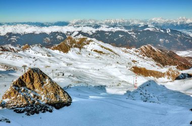 Zell am 'in geniş açılı hava manzarası güneşli Alp dağları zirveleri ve beyaz kayak yamaçları olan turizm beldesine bakın. 