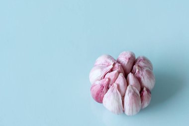 Mavi arka planda kalp şeklinde sarımsak başı