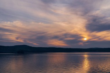 Gün batımında gölün üzerinde güzel bulutlar