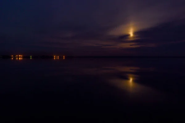 Размытые прекрасные облака и луна над озером — стоковое фото