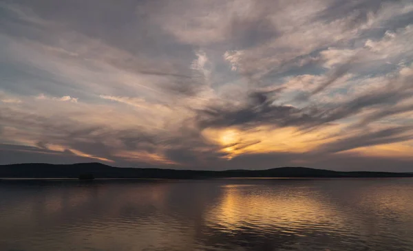 Hermosas nubes durante el atardecer sobre el lago Imagen de stock