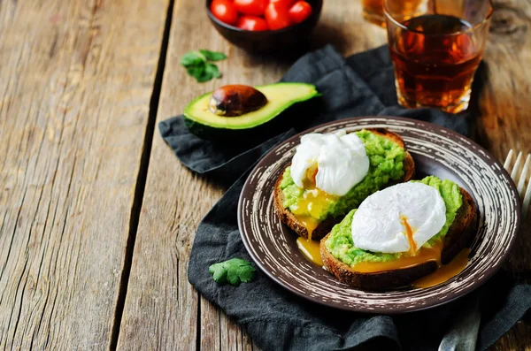 Poached egg Avocado Rye Toasts on a wood background. toning. selective focus