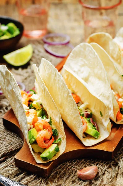 Shrimp tacos with avocado salsa on wood background. toning. selective focus