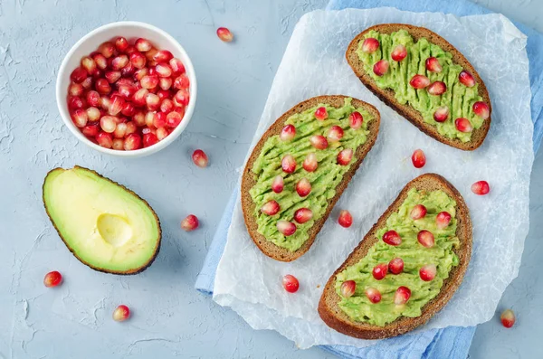 Smashed avocado pomegranate rye sandwiches