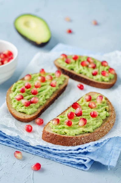 Smashed avocado pomegranate rye sandwiches