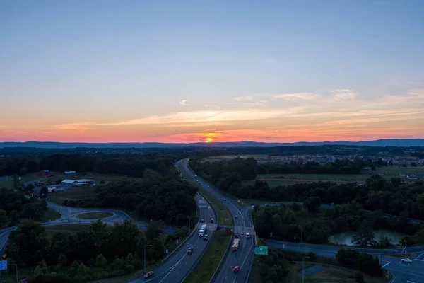 The sun sets behind Catoctin Mountain as cars and trucks travel on Interstate 270 in Urbana, Frederick County, Maryland.