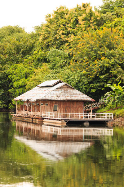 Floating house and reflection on the River Kwai in Kanchanaburi Thailand