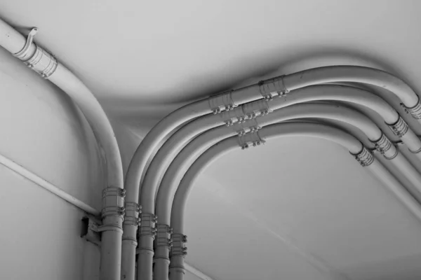 Труба лінії електропередачі на цементній стіні в чорно-білому тоні — стокове фото