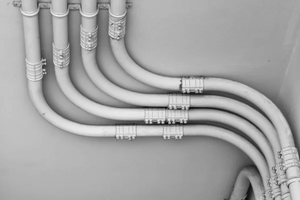 Pipe of electricity line on cement  wall in black and white tone — Stock Photo, Image