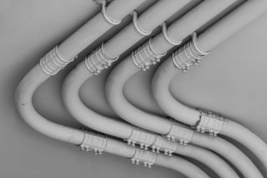 Çimento duvarında siyah beyaz tonlu elektrik hattı borusu