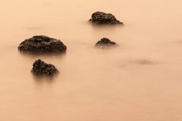 Золотое море и камень — стоковое фото