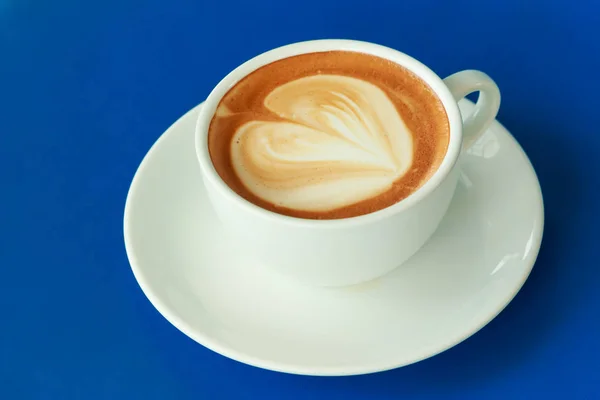 Filiżankę gorącej kawy na niebieskim stole — Zdjęcie stockowe