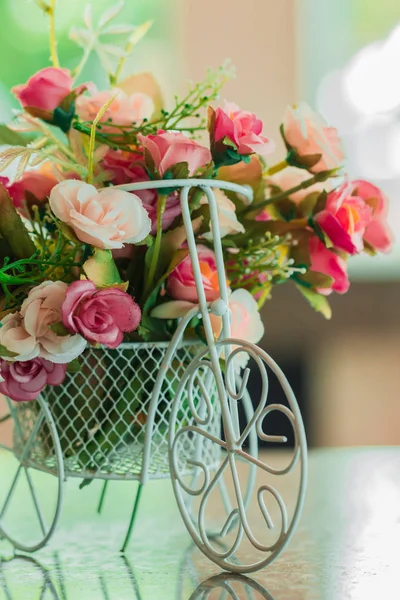 Искусственные цветы в белой велосипедной корзине на мраморном столе — стоковое фото