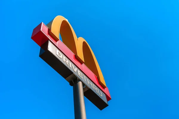 Mcdonaldsovo logo na modrém nebi pozadí v restauraci McDonald 's v oblasti dálnice REST, okres Bangpakong, provincie Chachoengsao, je to největší restaurace na této silnici v Thajsku. — Stock fotografie