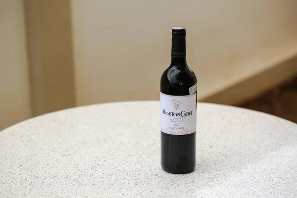 特写一瓶莫顿卡德波尔多白兰地2012年葡萄酒在白色的大理石办公桌上。它是法国最大的葡萄酒产区 — 图库照片