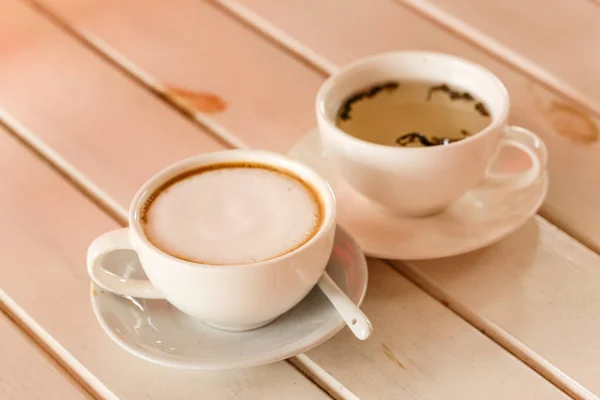 Gorąca kawa cappuccino i gorąca herbata na białym biurku — Zdjęcie stockowe