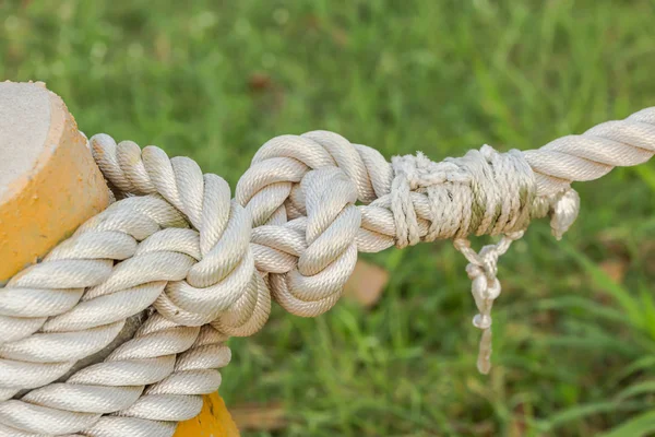 Big white rope tied yellow cement pole in close up nature background — Stock Photo, Image