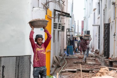 GHAZIABAD, UTTAR PRADESH / INDIA - Haziran 2020: Virüs ve Toz 'u önlemek için yüzünde tıbbi maske olan genç Hintli erkek işçi