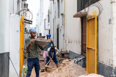 GHAZIABAD, UTTAR PRADESH / INDIA - Haziran 2020: Virüs ve Toz 'u önlemek için yüzünde tıbbi maske olan genç Hintli erkek işçi
