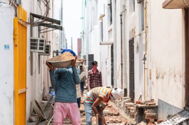 GHAZIABAD, UTTAR PRADESH / INDIA - Haziran 2020: Virüs ve Toz 'u önlemek için yüzünde tıbbi maske olan genç Hintli erkek işçi