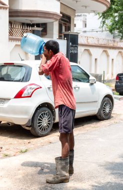 GHAZIABAD, UTTAR PRADESH / INDIA - Haziran 2020: Virüs ve Toz 'u önlemek için yüzünde tıbbi maske olan genç Hintli erkek işçi