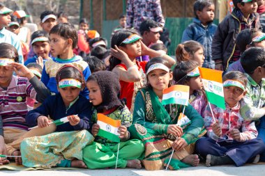 NOIDA, UTTAR PRADESH / INDIA - JANUARY 2020 : Young Indian students from Slum/Village area celebrating Indian Republic Day function at school with flags in hand clipart