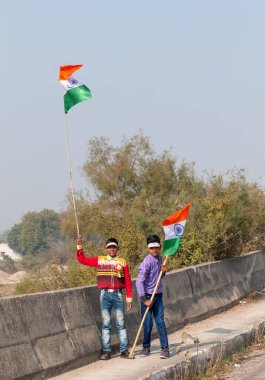 NOIDA, UTTAR PRADESH / INDIA - HAZİRAN 2020: Hindistan Cumhuriyeti Günü etkinliğini elinde bayraklarla kutlayan varoş / köy bölgesinden genç Hintli öğrenciler