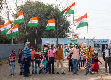 NOIDA, UTTAR PRADESH / INDIA - HAZİRAN 2020: Hindistan Cumhuriyeti Günü etkinliğini elinde bayraklarla kutlayan varoş / köy bölgesinden genç Hintli öğrenciler
