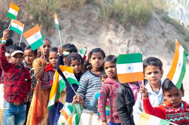 NOIDA, UTTAR PRADESH / INDIA - HAZİRAN 2020: Hindistan Cumhuriyeti Günü etkinliğini elinde bayraklarla kutlayan varoş / köy bölgesinden genç Hintli öğrenciler