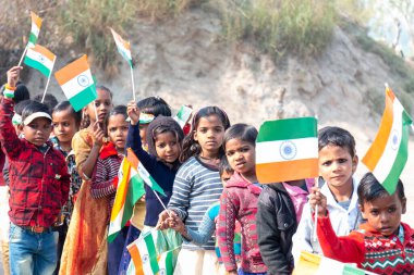 NOIDA, UTTAR PRADESH / INDIA - HAZİRAN 2020: Hindistan Cumhuriyeti Günü etkinliğini elinde bayraklarla kutlayan varoş / köy bölgesinden genç Hintli öğrenciler