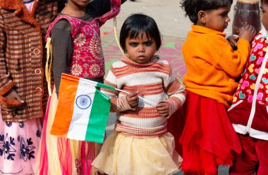 NOIDA, UTTAR PRADESH / INDIA - HAZİRAN 2020: Hindistan Cumhuriyeti Günü etkinliğini elinde bayraklarla kutlayan varoş / köy bölgesinden genç Hintli öğrenciler