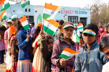 NOIDA, UTTAR PRADESH / INDIA - HAZİRAN 2020: Hindistan Cumhuriyeti Günü etkinliğini elinde bayraklarla kutlayan varoş / köy bölgesinden genç Hintli öğrenciler