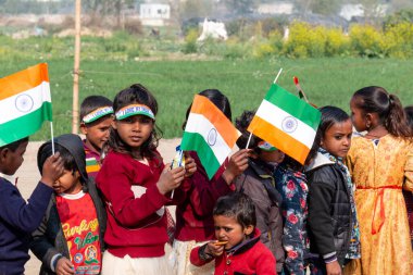 NOIDA, UTTAR PRADESH / INDIA - HAZİRAN 2020: Hindistan Cumhuriyeti Günü etkinliğini elinde bayraklarla kutlayan varoş / köy bölgesinden genç Hintli öğrenciler