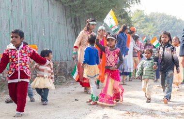 NOIDA, UTTAR PRADESH / INDIA - HAZİRAN 2020: Hindistan Cumhuriyeti Günü etkinliğini elinde bayraklarla kutlayan varoş / köy bölgesinden genç Hintli öğrenciler
