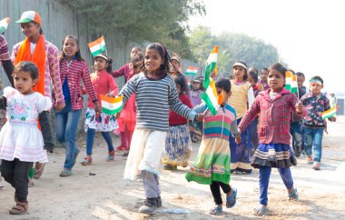 NOIDA, UTTAR PRADESH / INDIA - HAZİRAN 2020: Hindistan Cumhuriyeti Günü etkinliğini elinde bayraklarla kutlayan varoş / köy bölgesinden genç Hintli öğrenciler