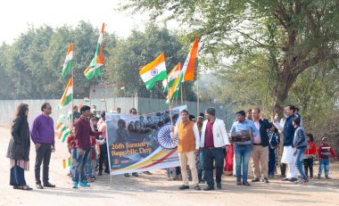 NOIDA, UTTAR PRADESH / INDIA - HAZİRAN 2020: Hindistan Cumhuriyeti Günü etkinliğini elinde bayraklarla kutlayan varoş / köy bölgesinden genç Hintli öğrenciler