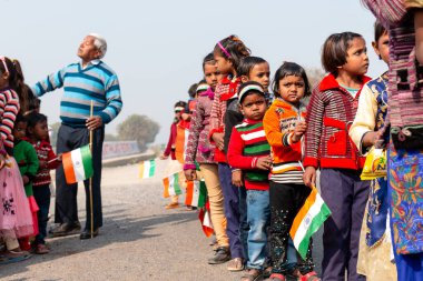 NOIDA, UTTAR PRADESH / INDIA - HAZİRAN 2020: Hindistan Cumhuriyeti Günü etkinliğini elinde bayraklarla kutlayan varoş / köy bölgesinden genç Hintli öğrenciler