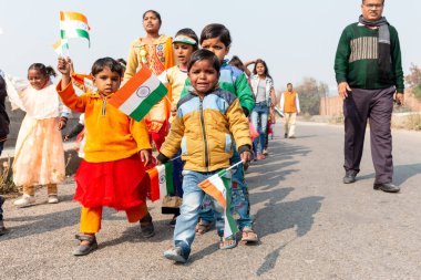 NOIDA, UTTAR PRADESH / INDIA - HAZİRAN 2020: Hindistan Cumhuriyeti Günü etkinliğini elinde bayraklarla kutlayan varoş / köy bölgesinden genç Hintli öğrenciler