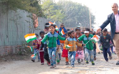 NOIDA, UTTAR PRADESH / INDIA - HAZİRAN 2020: Hindistan Cumhuriyeti Günü etkinliğini elinde bayraklarla kutlayan varoş / köy bölgesinden genç Hintli öğrenciler