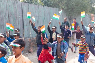 NOIDA, UTTAR PRADESH / INDIA - HAZİRAN 2020: Hindistan Cumhuriyeti Günü etkinliğini elinde bayraklarla kutlayan varoş / köy bölgesinden genç Hintli öğrenciler