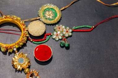 Hint festivali, Raksha Bandhan arkaplanı zarif renkli Rakhi, Gift, Rice Grains ve Kumkum. Geleneksel Hint bilekliği Kardeşler ve Kız Kardeşler arasındaki aşkın sembolüdür..