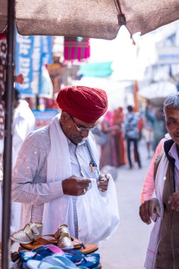 Varanasi, Uttar Pradesh, Hindistan - 21 Ocak 2024: Varanasi 'deki çetelerin yakınındaki ghat' larda geleneksel giyinmiş kimliği belirsiz yaşlı bir Brahmin 'in portresi