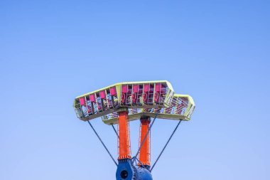 Eğlence parkı turu açık mavi gökyüzüne karşı yükseliyor